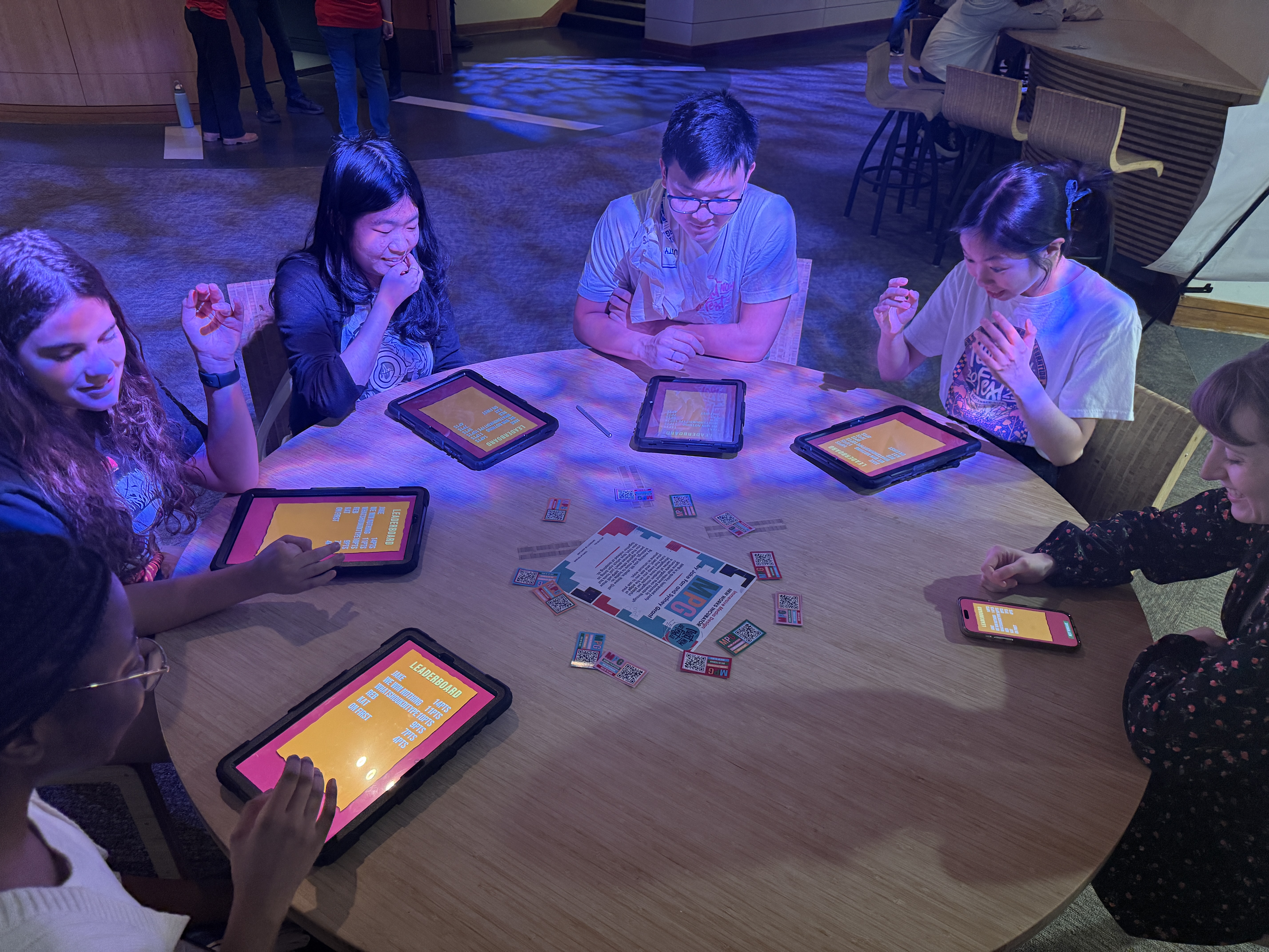 On the left, a mockup of the MPG app on an iPhone 16, featuring the MPG logo, a host game button, and a join game button. On the right, the MPG logo and a tagline, 'a quirky, fast-paced mobile party game.'